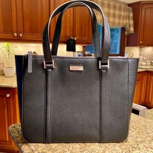 Kate Spade black leather tote bag with gold accents and striped liner